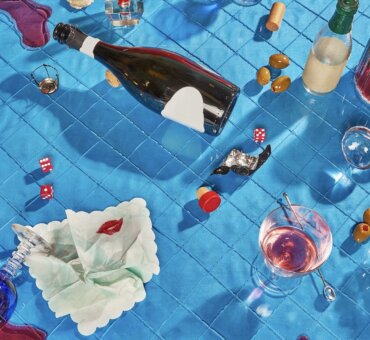 Drinks And Olives Are Scattered Across A Blue Tiled Surface With A Bottle And Glass Tipped Over And Spilled Drinks