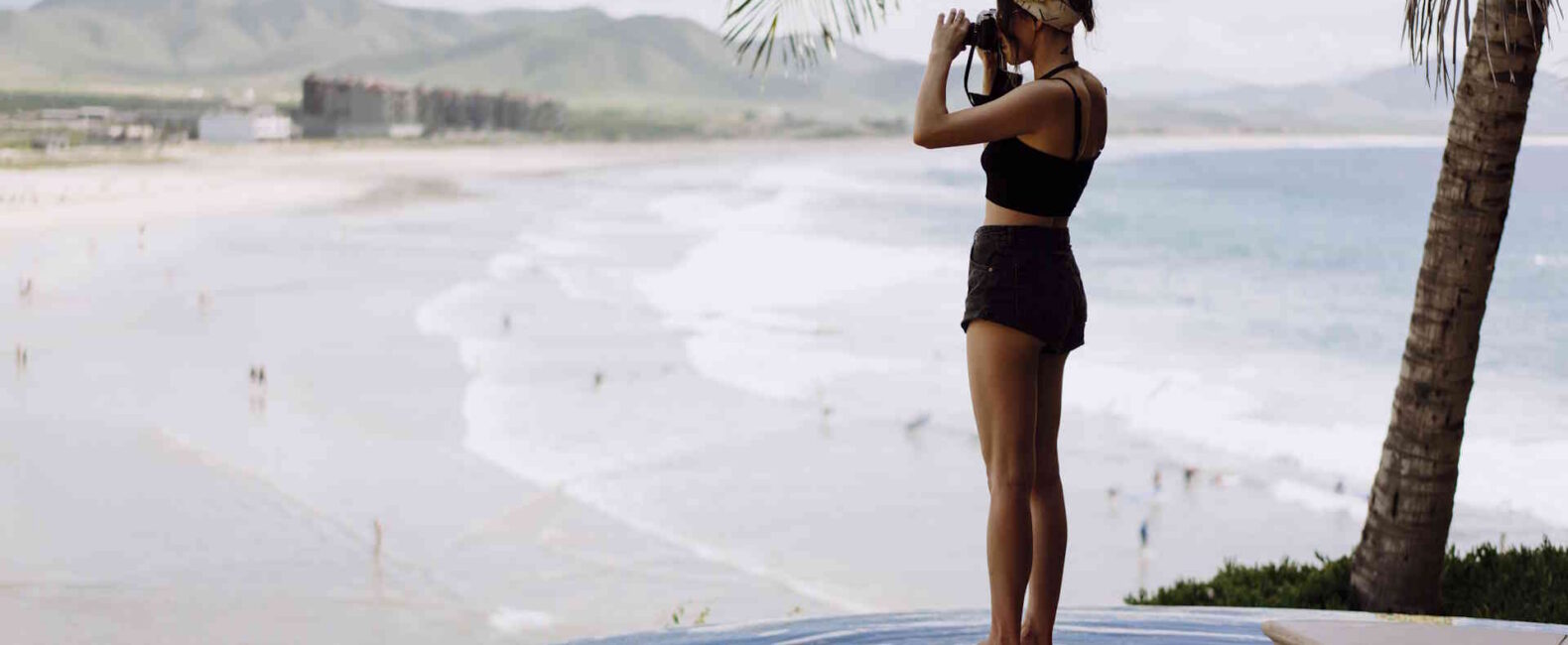A Woman Stands On The Edge Of An Infinity Pool