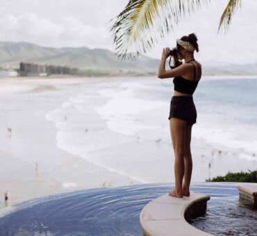 A Woman Stands On The Edge Of An Infinity Pool